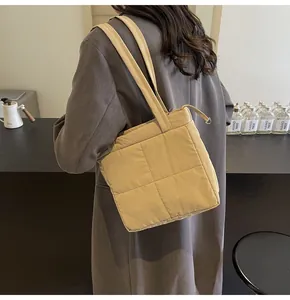 Dettaglio della borsa trapuntata beige con cuciture a rombi e chiusura lampo argento
