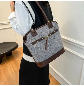 Detail of vintage gray tweed and brown leather tote bag with gold metal buckles