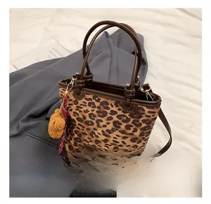 Dettaglio della borsa a secchiello leopardata con manici marroni e ciondolo a orsetto