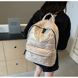 Close-up of metallic quilted backpack with champagne gold finish and black zipper detail