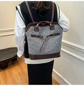 Close-up of grey tweed backpack with brown leather straps worn by a model in a studio