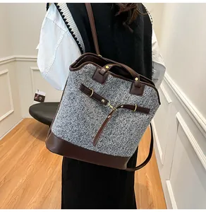 Macro view of grey tweed and brown leather paneling on the shoulder tote bag