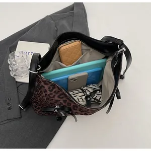 Vista interior del bolso tote de leopardo mostrando gran capacidad para tableta y accesorios