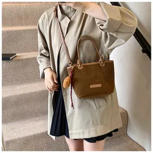Borsa tote in camoscio marrone con manici in pelle e ciondolo in peluche su scale interne