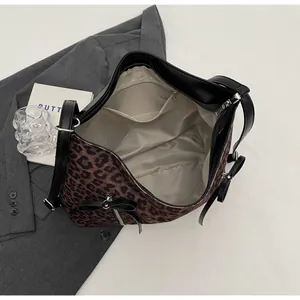 Detalle interior de bolso tote de leopardo con bolsillo de cremallera y lazos negros