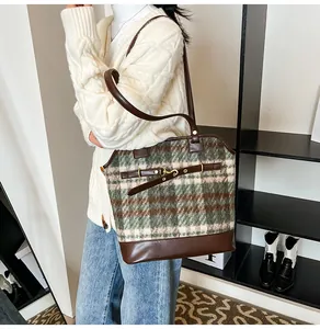 Detail showing the green plaid wool texture and horsebit buckle on retro tote bag