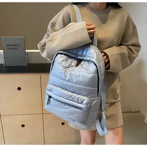 Quilted puffer backpack in light blue shown worn by a model in a modern interior