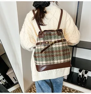 Detail of vintage plaid tote bag with leather trim and horsebit on model with white sweater
