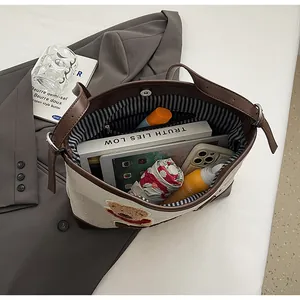 Beige tote bag with brown handles showing spacious interior for tablet and books