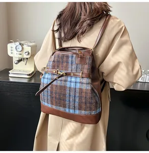 Detailed view of the plaid fabric and brown leather stitching on the vintage tote bag