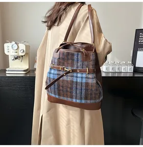 Detail of vintage plaid tote bag featuring brown faux leather strap and buckle on shoulder