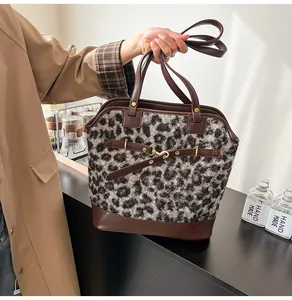 Detail of grey leopard print plush tote bag with leather base and metal buckle accents