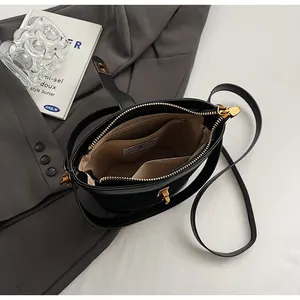 Vue détaillée de l'intérieur du sac en cuir noir avec compartiments et fermoir doré
