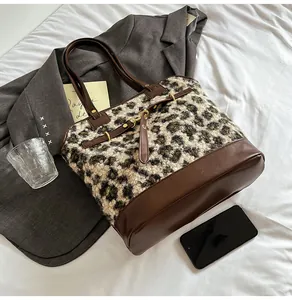 Close-up of leopard print fabric texture and dark brown leather straps on tote bag
