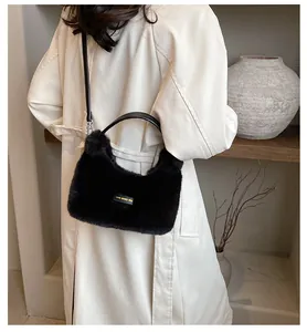 Close-up of fluffy black faux fur bag with love every day tag worn by a model