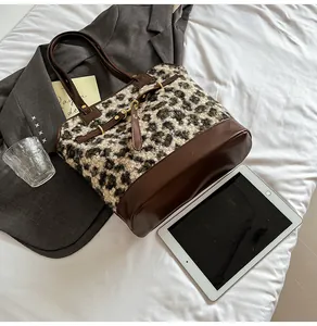Close-up of leopard print faux fur and brown leather stitching on a tote bag