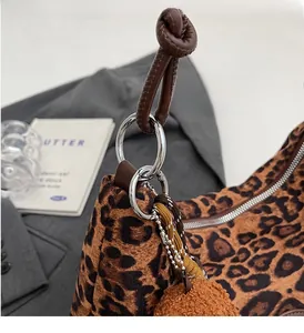 Detail of silver hardware and leather knot handle on leopard print tote bag
