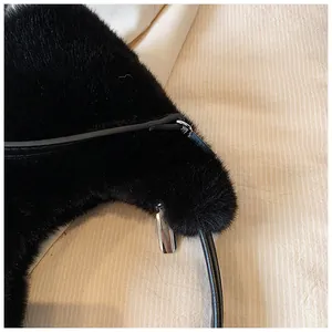 Detail view of the black faux fur crescent bag showing dense texture and silver zipper