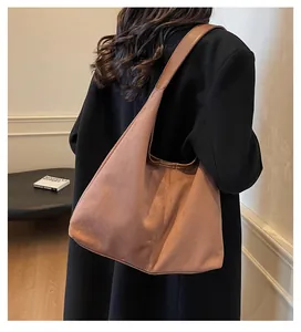Detail of large brown suede shoulder bag showing natural drape and spacious minimalist design