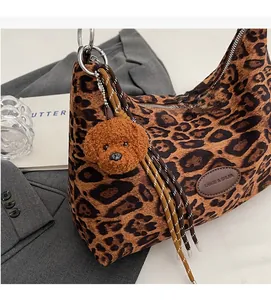 Close-up of leopard print tote bag with teddy bear charm and metal ring handle