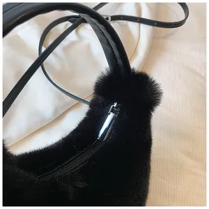 Close-up of black faux fur handbag featuring silver zipper and leather strap detail