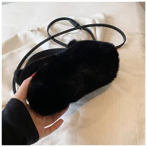 Close-up of soft black faux fur crossbody bag with adjustable leather shoulder strap