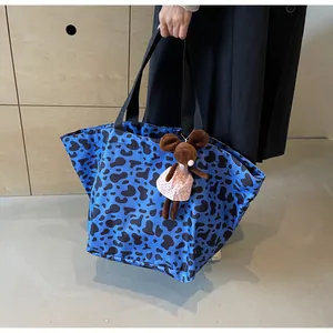 Borsa tote blu con stampa leopardata, manici neri e ciondolo a forma di peluche carino