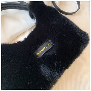 Detail of black faux fur handbag featuring soft plush texture and love every day tag