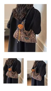 Close-up of leopard print tote bag fabric with plush puppy charm and tassel detail