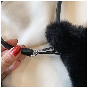 Close-up of fluffy black faux fur bag texture with silver metal lobster clasp and leather strap