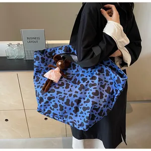 Dettaglio della borsa tote blu con stampa leopardata e ciondolo a forma di topo