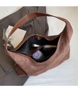 Detailed view of spacious brown suede tote bag interior with magnetic closure and inner pockets
