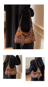 Macro detail of leopard print tote bag with brown leather straps and plush bear charm