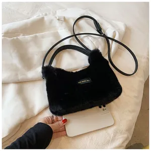 Size comparison of a black faux fur handbag with a smartphone and leather straps
