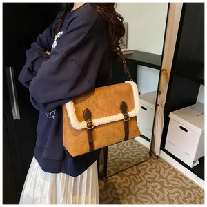 Detail van de pluche rand op bruine suède crossbodytas met vintage gouden gespen
