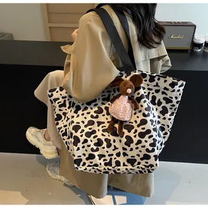 Dettaglio della grande borsa tote maculata con tracolla nera e ciondolo a topolino