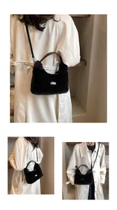 Detail of black plush faux fur crossbody bag featuring leather handles and brand tag