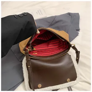 Detailweergave van de lamswollen rand en de gestreepte voering van de bruine crossbodytas