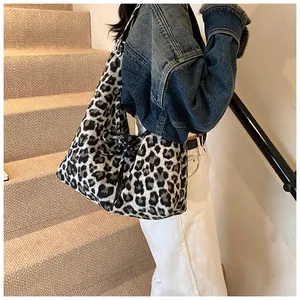 Detail of leopard print tote bag featuring black decorative ribbon bow and canvas texture