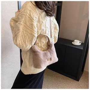 Chic light brown faux fur bag with gold hardware shown on a cream knit sweater