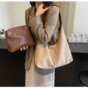 Detail of beige suede tote bag with brown leather strap and matching pouch set