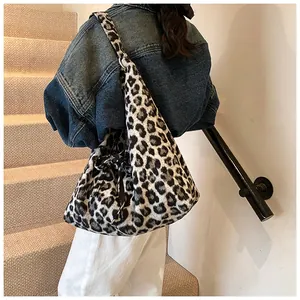 Detail of leopard print plush tote bag with a black silk bow ribbon on the shoulder strap