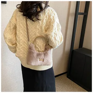 Detail of grey faux fur handbag showing plush texture and gold engraved metal plate