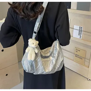 Detailansicht der silbernen Hobo-Tasche mit Knitteroptik und kleinem Bärenanhänger