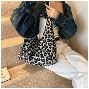 Close-up of soft leopard print tote bag texture with black strap details in lifestyle setting