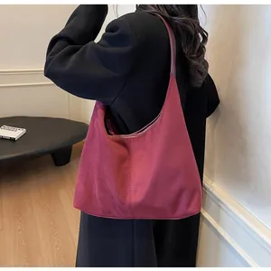 Detail view of burgundy matte tote bag showing suede texture and slender shoulder strap