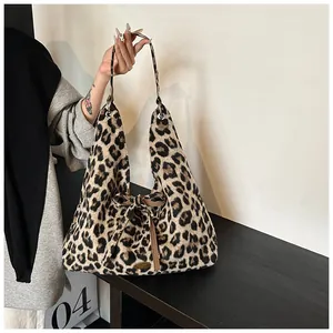 Detail of leopard print faux fur tote bag with brown leather bow and metal logo plate