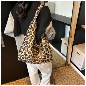Detail view of leopard print tote bag with side drawstring and metal logo plate