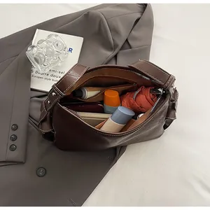 Vista dall'alto dell'interno capiente di una borsa marrone con telefono e ombrello