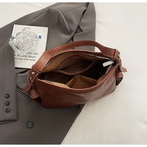 Dettaglio interno borsa a secchiello in pelle marrone con tasca zip e fodera interna